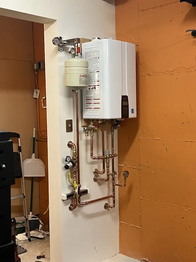 Plumbing technician inspecting water heater connections in Rockwell